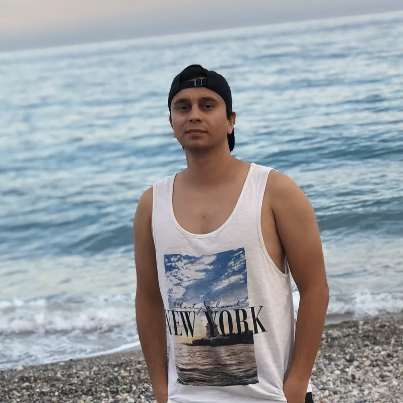 Abozar in a cap on the beach at Finale Ligure at sunset