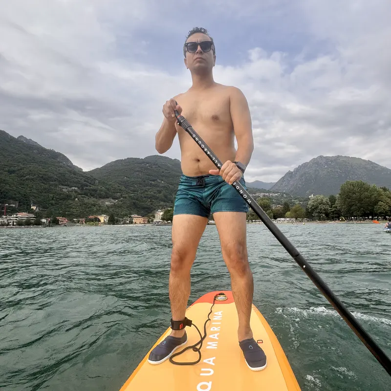 Abozar standing on a yellow paddleboard on Lake Lugano