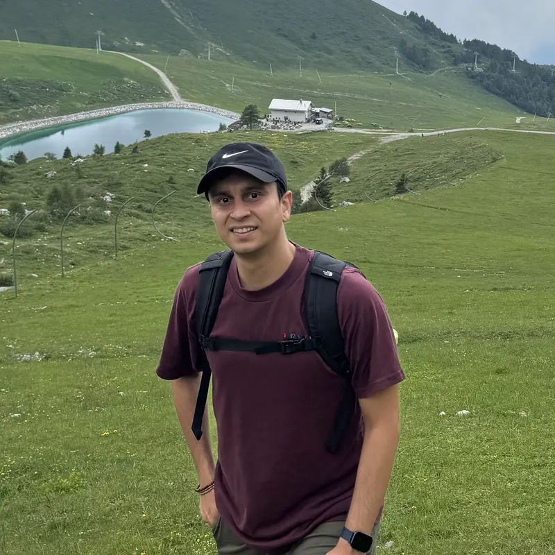 Abozar with a backpack in a green mountain meadow at Piani di Bobbio